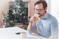 Pleasant adult man drinking juice in the morning