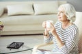 Pleasant aged woman drinking tea