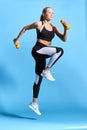 Pleasant beautiful woman in stylish sportswear working out with dumbbells Royalty Free Stock Photo