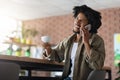 Pleasant Call. Black Guy Talking On Cellphone And Drinking Coffee At Cafe Royalty Free Stock Photo