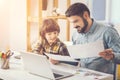 Pleasant caring father helping his son with school homework