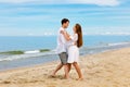 Pleasant couple of young people in love dancing on the sea beach