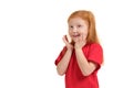 Pleasant cute upbeat little girl holding her hands near face and smiling while expressing joy.