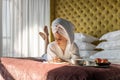 Pleasant domestic business woman in towel robe taking notes reminder in notepad lying on luxury bed Royalty Free Stock Photo