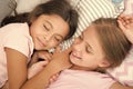Pleasant dream on her mind. Girls fall asleep after pajamas party in bedroom. Girls have healthy sleep. Children relax