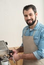 Pleasant experienced barman making tasty coffee and smiling