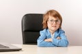 Pleasant ginger boy with sceptic expression looking at the camera