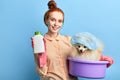 Pleasant ginger girl going to wash her pet with foam in the basin