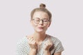 Pleasant girl with hairbun and glasses blowing sweet kiss. Royalty Free Stock Photo