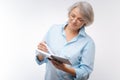 Pleasant grey-haired woman reading her notes Royalty Free Stock Photo