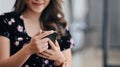 Pleasant happy woman using smart phone while sitting in office. Royalty Free Stock Photo