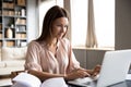 Pleasant happy young woman freelancer working on computer.