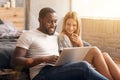 Pleasant international couple using laptop at home Royalty Free Stock Photo