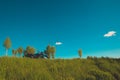 Pleasant landscape: old blue sky and clouds, green grass, a sunny meadow and an old retro vintage blue sidecar motorbike. A happy Royalty Free Stock Photo