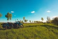 Pleasant landscape: old blue sky and clouds, green grass, a sunny meadow and an old retro vintage blue sidecar motorbike. A happy Royalty Free Stock Photo