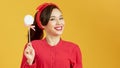 Pleasant looking cheerful woman poses with delicious lollipop enjoys leisure time against yellow background