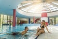 Pleasant loving couple resting near swimming pool