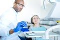 Pleasant male dentist putting mouth mirror on tray