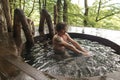 Man with curly hair is swimming in the wooden jacuzzi after using the sauna Royalty Free Stock Photo