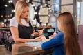 Pleasant manicurist removing cuticle from clients nails Royalty Free Stock Photo