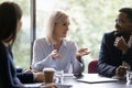 Pleasant mature businesswoman offering project to diverse customers on negotiations Royalty Free Stock Photo