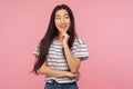 Pleasant memories. Portrait of girl with long hair in striped t-shirt smiling and dreaming something pleasant Royalty Free Stock Photo