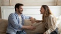 Pleasant millennial family couple having cheerful conversation at living room Royalty Free Stock Photo