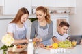 Pleasant mother cooking dinner with her children