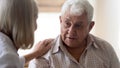 Pleasant older man thanking middle aged nurse for psychological help. Royalty Free Stock Photo