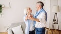 Pleasant senior couple dancing and smiling to each other Royalty Free Stock Photo