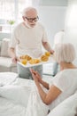 Pleasant senior man holding a tray with food Royalty Free Stock Photo