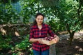 Pleasant woman farmer carrying a wooden crate of harvested organic potatoes. Eco farming. Vegetable delivery concept