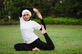 Pleasant woman in hijab and sportswear doing yoga and stretching.