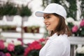 Pleasant woman posing at greenhouse with colorful flowers Royalty Free Stock Photo