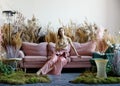 Pleasant woman posing in a living room in the middle of tall grass