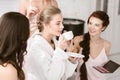 Pleasant young bride drinking tea and getting ready