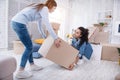 Pleasant young girl helping her roommate lift up box Royalty Free Stock Photo