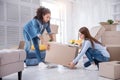 Pleasant young girls lifting up heavy box together Royalty Free Stock Photo