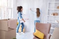 Pleasant young girls measuring wall to hang a picture Royalty Free Stock Photo