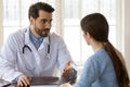 Pleasant young handsome male doctor talking to patient. Royalty Free Stock Photo