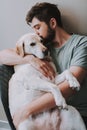 Pleasant young man kissing his dog while expressing love Royalty Free Stock Photo