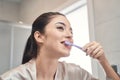 Pleasant young woman cleaning her teeth at bathroom Royalty Free Stock Photo