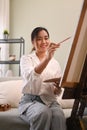 Pleasant young woman painting picture with watercolor at cozy home. Art, creative hobby and leisure activity concept Royalty Free Stock Photo