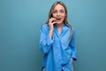 pleasantly surprised cute blonde woman chatting on the phone on a blue bright background Royalty Free Stock Photo