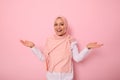 Pleasantly surprised gorgeous Arab muslim woman with covered head in pink hijab joyfully looks at camera smiling beautiful toothy