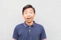 Pleasantly surprised Indonesian guy on a white background
