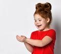 Pleasantly surprised red-haired girl happily looking at something lying in her palms. Royalty Free Stock Photo