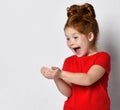 Pleasantly surprised red-haired girl happily looking at something lying in her palms. Royalty Free Stock Photo