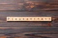 pleasantness word written on wood block. pleasantness text on cement table for your desing, concept Royalty Free Stock Photo