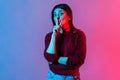 Please, be quiet. Neon light portrait of young woman showing hush with finger on her lips gesture, shushing Royalty Free Stock Photo